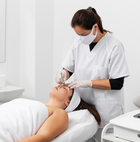 A woman  having her eyebrows sculpted, with a beautician working meticulously on her brows.